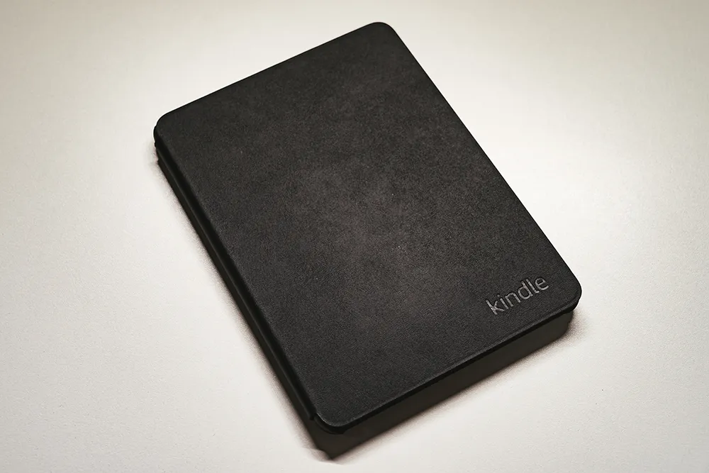 Amazon純正 植物性レザーカバー（Kindle Paperwhite 第12世代・Kindle ColorSoft用、ブラック）外観。正面にkindleロゴ刻印