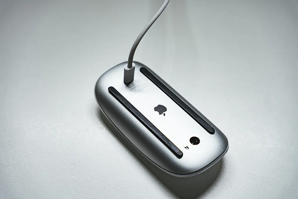Magic Mouse を裏返して充電している写真。
