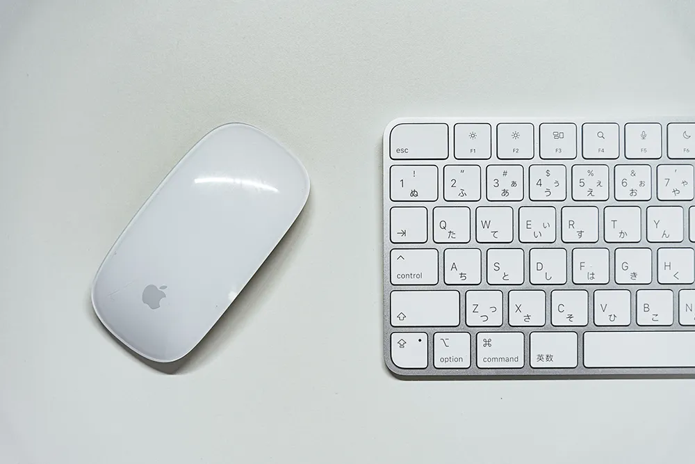 Magic Mouse と Touch ID 搭載 Magic Keyboard を並べたデスク環境の写真。